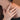 Model hand view featuring a gold band with a striking black gemstone worn gracefully on a hand posed against the neck.