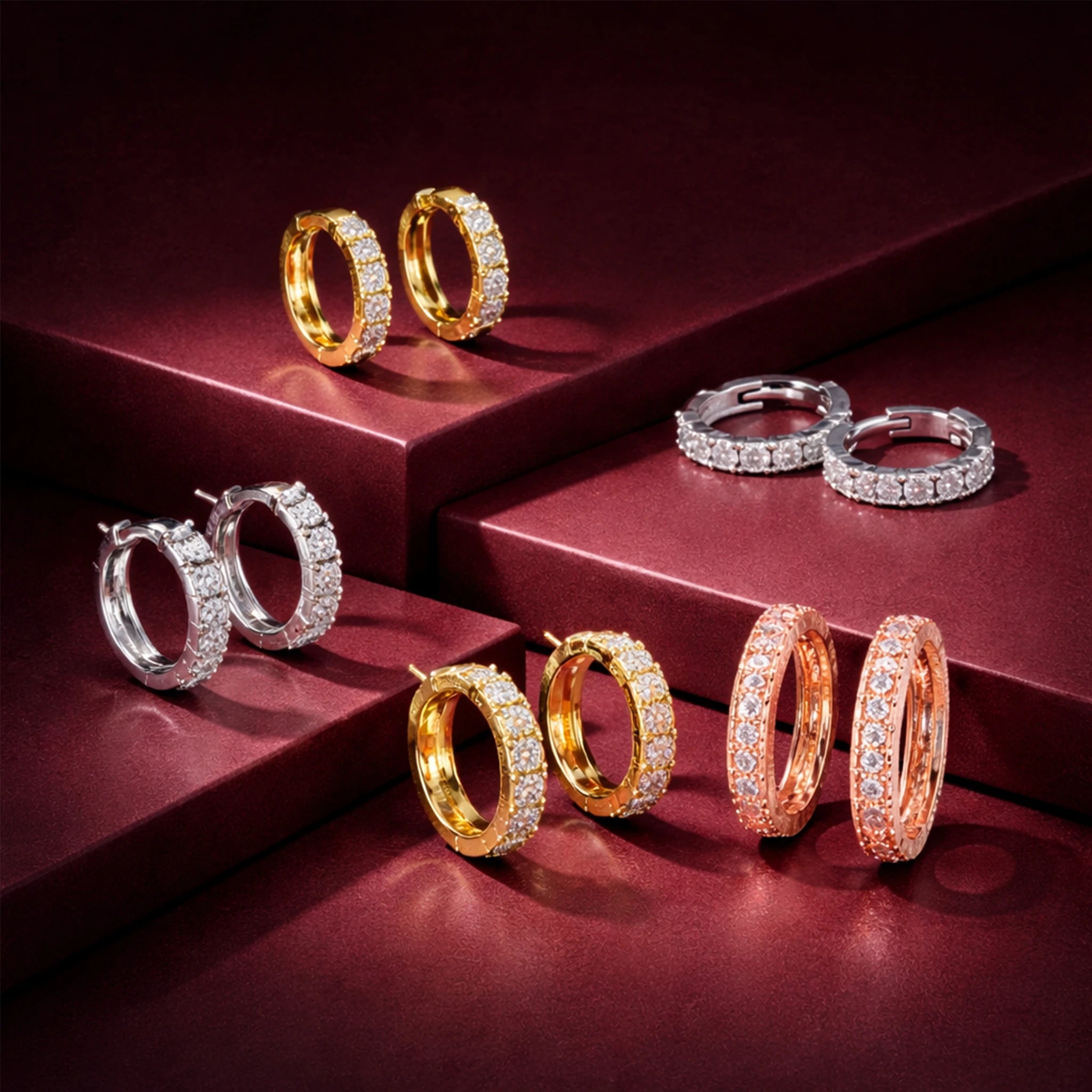 Luxury lab grown diamond hoop earrings in gold, silver and rose gold finish displayed on red steps.
