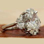 Side View Of 8.9 Oval Cut diamond engagement ring paired with half-moon cut