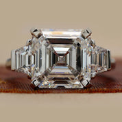 Front View Of 6.84 Ct Asscher Cut Three Stone Diamond Engagement Ring with Step-Cut Side Stones